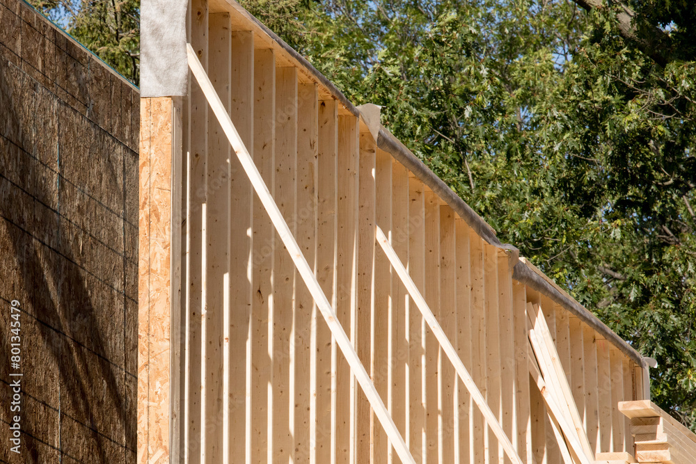 a wall of frame construction house showing wall studs and sheathing with bracing a wall of frame construction house showing wall studs and sheathing with bracing