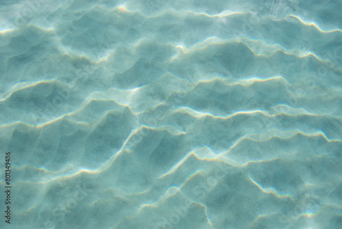 USA, United States Virgin Islands, St. John, Patterns in sand beneath light reflecting on water surface photo