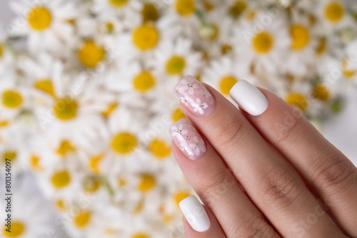 Beautiful female hand with pink and white manicure nails, flower design
