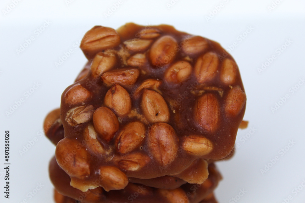 Gula kacang, or Ampyang, is a traditional snack from Indonesia, made from roasted peanuts and brown sugar. Isolated on white background Gula kacang, or Ampyang, is a traditional snack from Indonesia, made from roasted peanuts and brown sugar. Isolated on white background