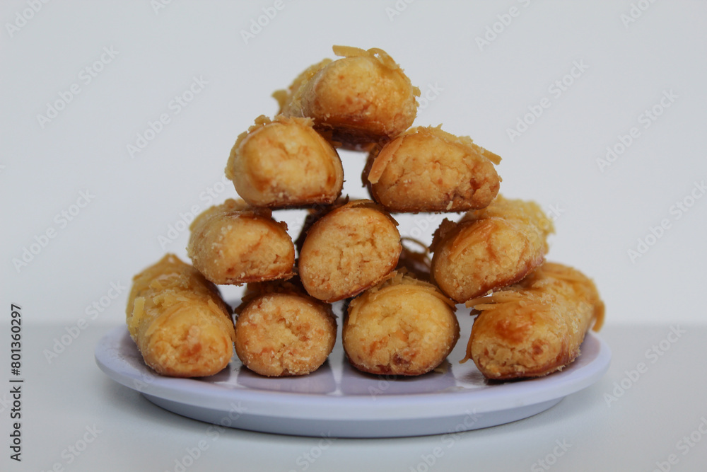 Kaasstengels or Kastengel, is Dutch influenced Indonesian cheese cookies in the form of sticks. Isolated in white background Kaasstengels or Kastengel, is Dutch influenced Indonesian cheese cookies in the form of sticks. Isolated in white background