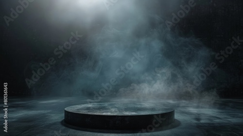 A spotlight shines down on a dark stage with a smoky atmosphere.