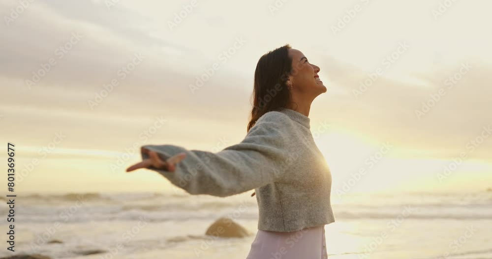 Ocean, sunset and woman with smile for freedom in vacation, weekend holiday and journey in California. Summer, female person and happy with raised hands in beach for fresh air or peace outdoors