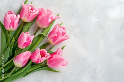 A bouquet of pink tulips is arranged in a vase on a white background