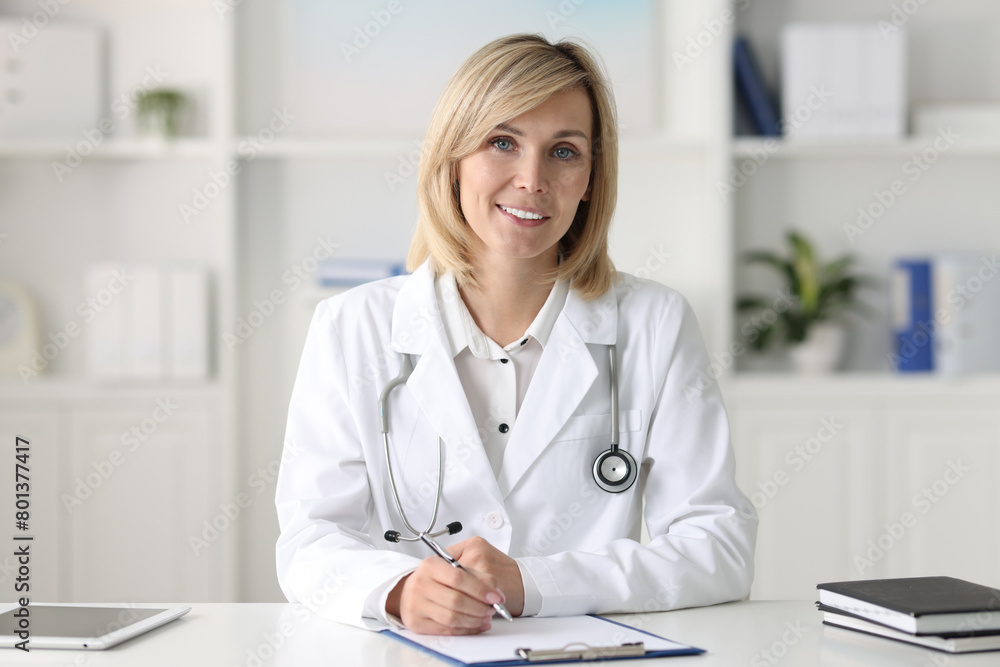 Portrait of smiling doctor at table in office Portrait of smiling doctor at table in office