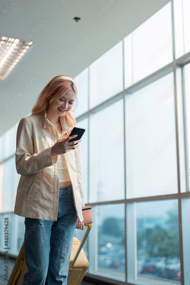 A woman asian walking in an airport. Mobile, suitcase and travel with a young female on an trip for work or travel A woman asian walking in an airport. Mobile, suitcase and travel with a young female on an trip for work or travel