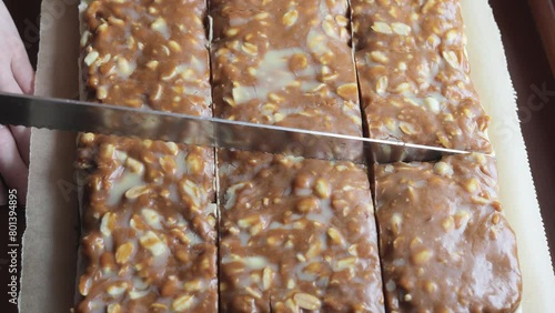 Cutting caramel peanut cake. Woman's hand cuts cake