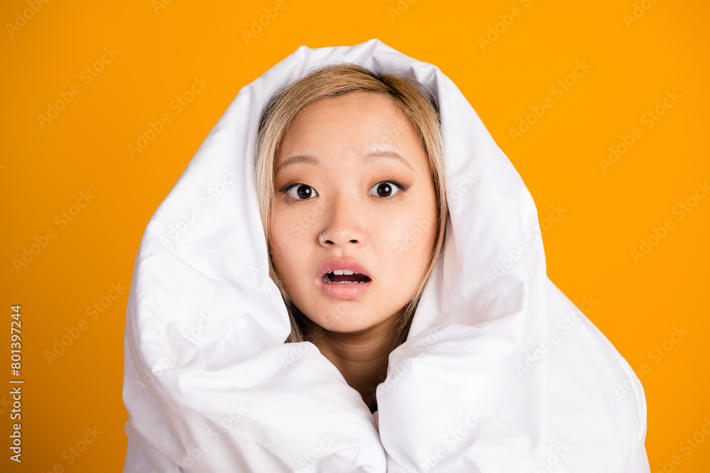 Photo of worried nervous lovely woman wrapped warm blanket isolated on yellow color background Photo of worried nervous lovely woman wrapped warm blanket isolated on yellow color background