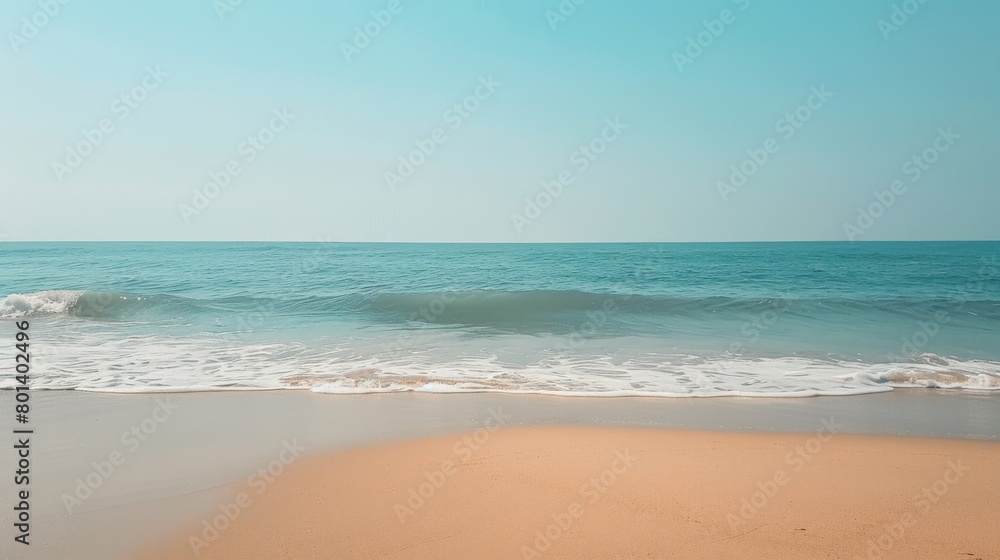Serene beach landscape: Gentle waves and golden sand under clear sky Serene beach landscape: Gentle waves and golden sand under clear sky