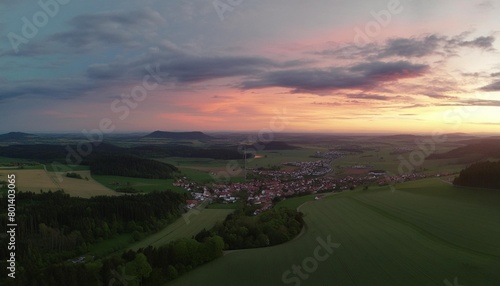 aerial panorama of a vast landscape with a small town at a gorgeous colorful sunset with dramatic sky