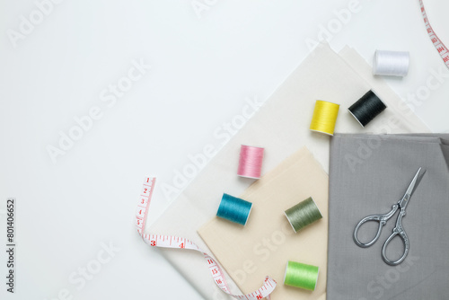 Composition with various threads and sewing accessories on white background