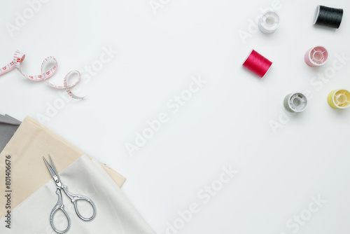 Composition with various threads and sewing accessories on white background. Top view, copy space