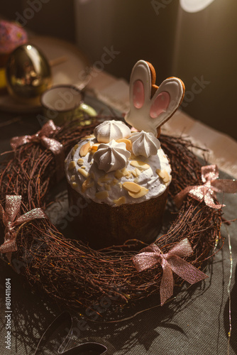 Easter decoration of colorful eggs in a basket and a rabbit on the kitchen table in a rustic style. Festive interior of a country house