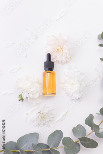 Cosmetic nature oil organic for skincare. Pipette bottle with serum and flowers on white background, place for product, top view