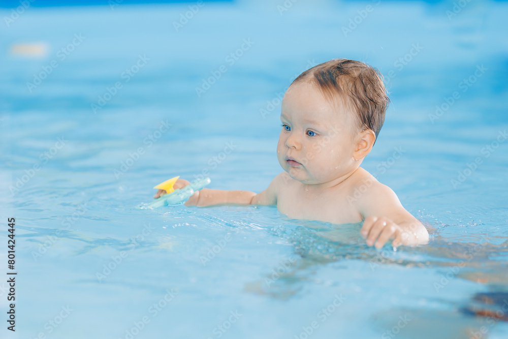 Portrait happy baby girl in swimming pool, teaching small swimmer. Concept healthcare sport for infant