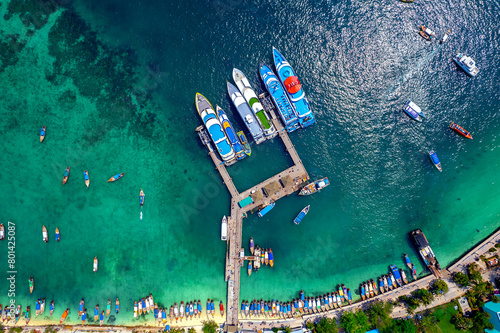 Aerial top view pier with thai long tail boat and taxi yacht in turquoise sea. Phi Phi Island, Thailand photo