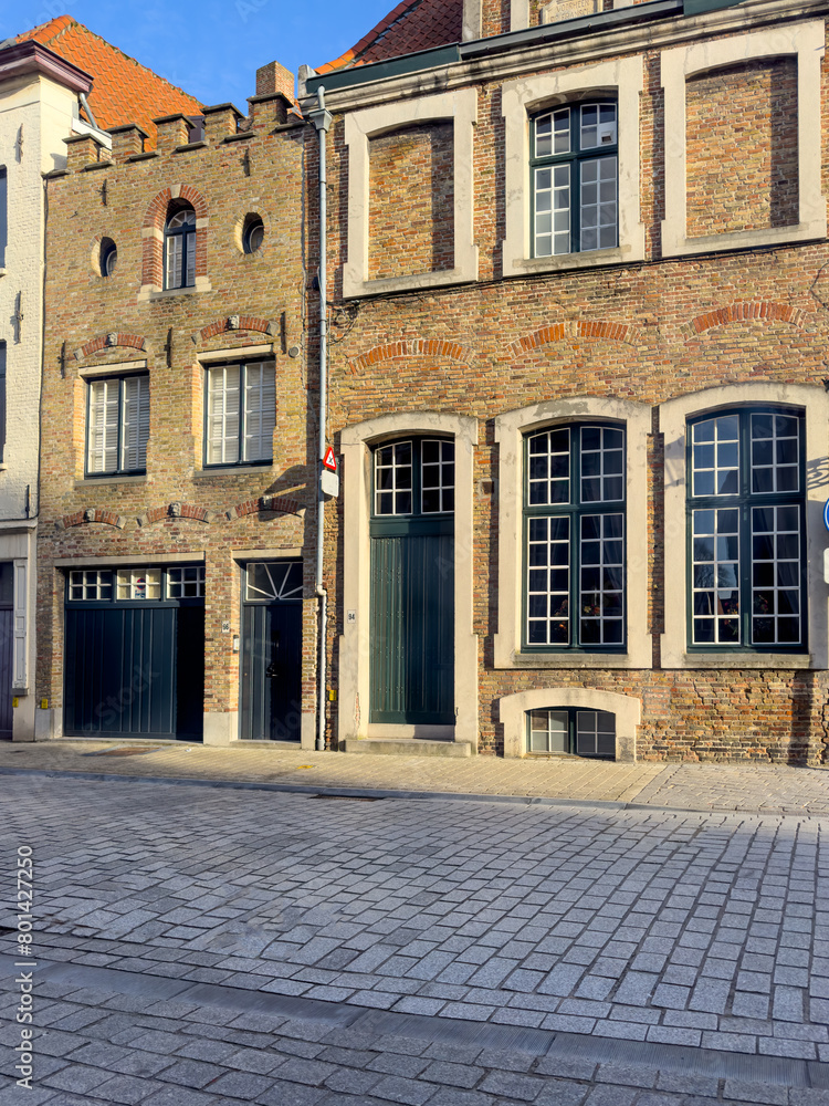 Street view of the famous touristic city of Belgium, Bruge, and its houses with classical medieval architecture Street view of the famous touristic city of Belgium, Bruge, and its houses with classical medieval architecture