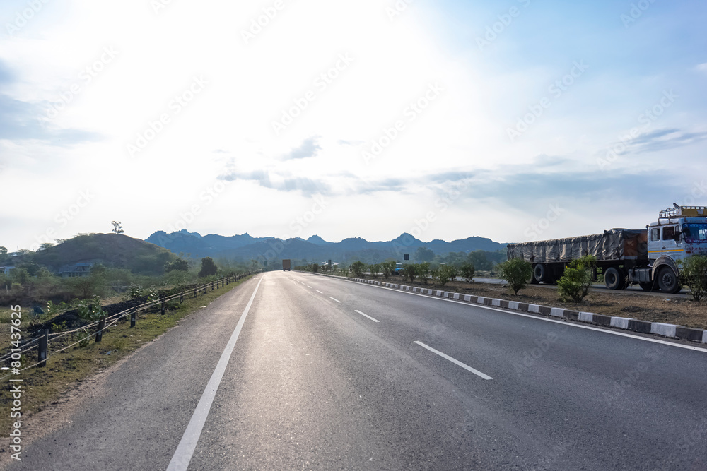 Landscape of Indian national highways surrounded by aravalli hills under the blue sky. National highways connected different cities and also saves time and fuel.