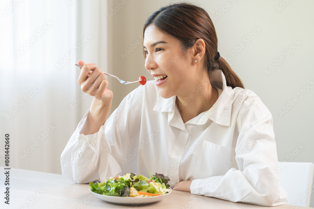 Diet concept, happy smile asian young woman use fork to prick tomato, fresh vegetable or green salad, eat nutrition food isolated on background, low fat to good body, getting weight loss for healthy.