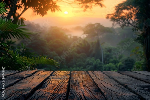 A wooden table with a view of a forest and a sunset in the background