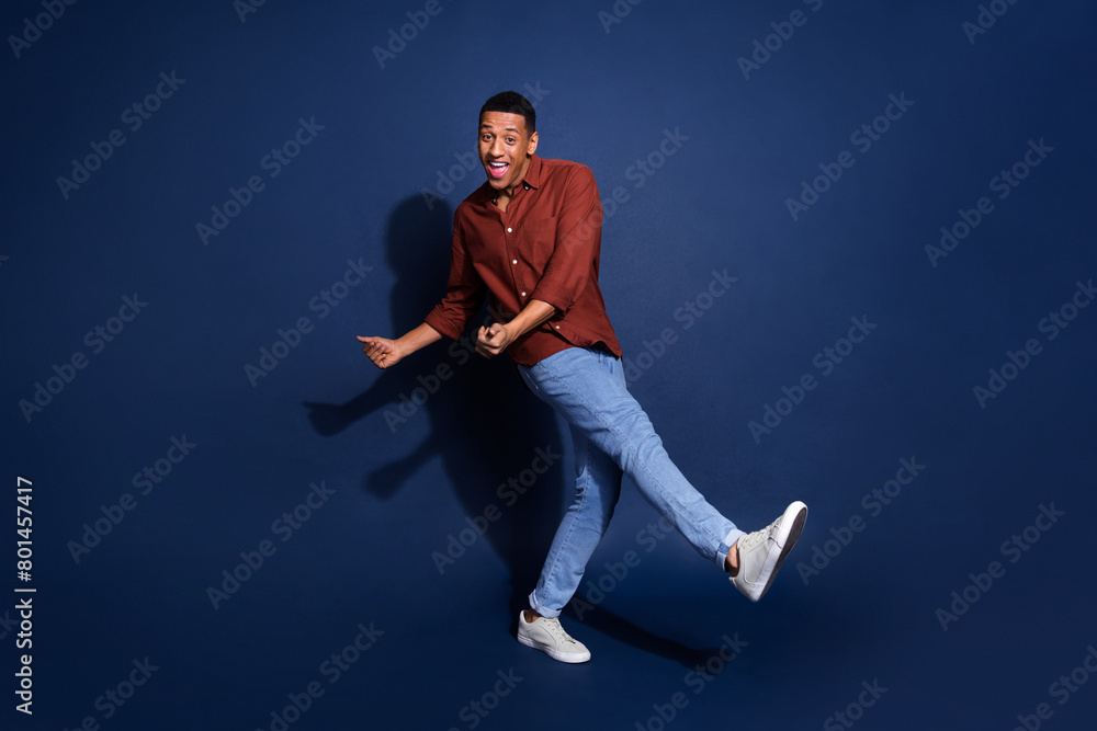 Full length photo of attractive funny guy wear formal shirt dancing emtpy space isolated blue color background