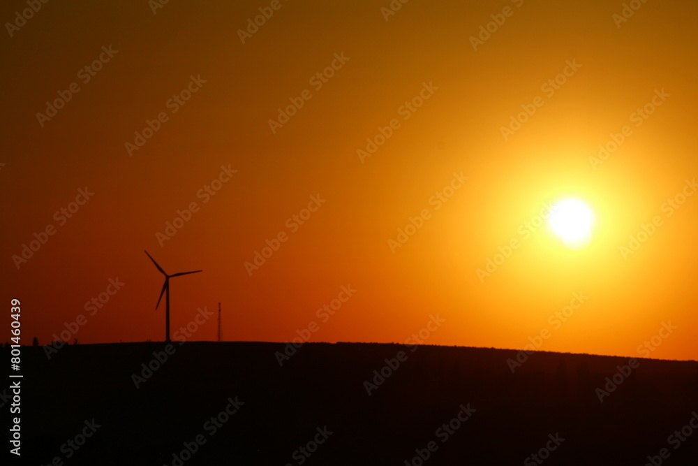 Obraz premium A sunset with a few wind turbines