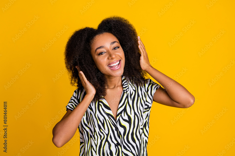 Portrait photo of glamour young charming woman touching huge chevelure wavy hair in zebra print shirt isolated on yellow color background Portrait photo of glamour young charming woman touching huge chevelure wavy hair in zebra print shirt isolated on yellow color background