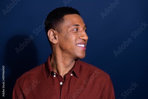 Photo of young man look empty space wear brown shirt isolated on dark blue color background photo