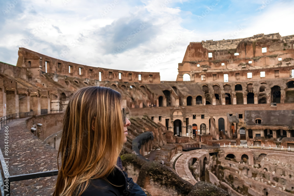 Tourist woman enjoying the view on interior of famous Colosseum of city of Rome, Lazio, Italy, Europe. UNESCO World Heritage Site. Flavian Amphitheater the symbol of ancient Roma city in Roman Empire