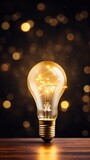 Gold backdrop with illuminated lightbulb on a white platform symbolizing ideas and creativity business concept creative thinking innovation new idea gold 