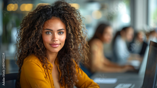 Afro business woman looking at you working in a modern office