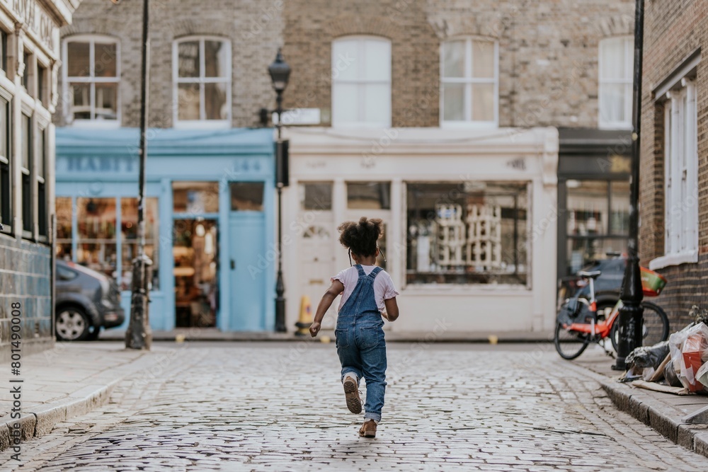 Happy African-American girl running on the street Happy African-American girl running on the street