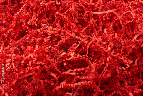 Textured background of holiday red crinkled shredded paper