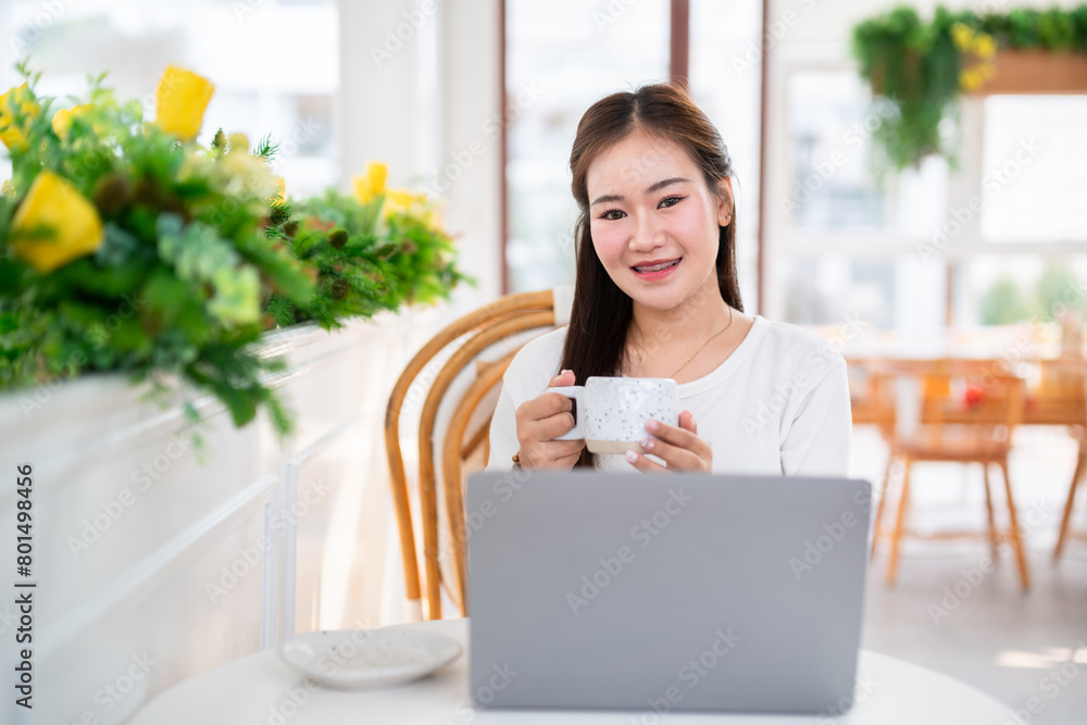 Close-up of hands Holding cup mug of Hot coffee latte wits business female casual working with laptop computer in coffee shop like the background,communication concept