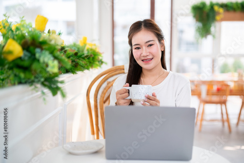 Obraz na płótnie Close-up of hands Holding cup mug of Hot coffee latte wits business female casual working with laptop computer in coffee shop like the background,communication concept w salonie
