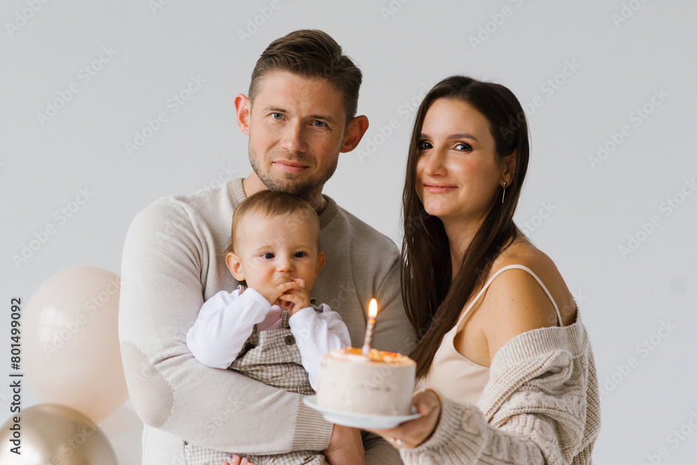 Happy parents mom and dad with their son celebrate birthday with cake and balloons Happy parents mom and dad with their son celebrate birthday with cake and balloons