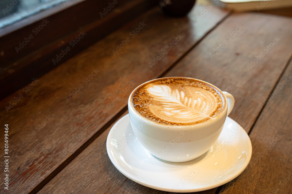 Hot coffee latte with latte art milk foam in cup mug on wood desk on top view. As breakfast In a coffee shop at the cafe,during business work concept,vintage style
