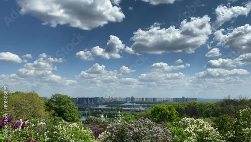 A panorama of the city of Kyiv and the Dnieper River opens from the botanical garden. The capital of Ukraine Kyiv against the background of a blue sky with white clouds. Below is the Dnieper River and