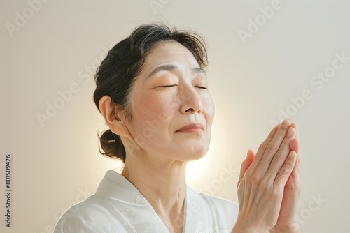 Japanese Woman Practicing Traditional Facial Massage for Youthful Skin in Serene Beige and White Setting