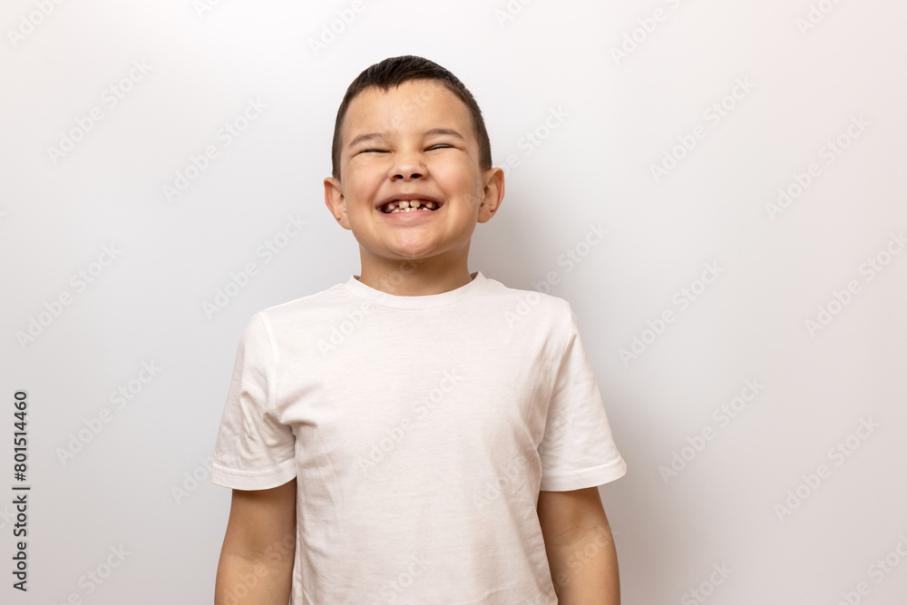 The guy smiles slyly, showing his teeth. Sincere children's emotions. The guy smiles slyly, showing his teeth. Sincere children's emotions.