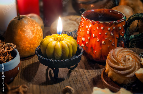 Space with lighted candle on a wooden table. Evening tea party. Halloween concept