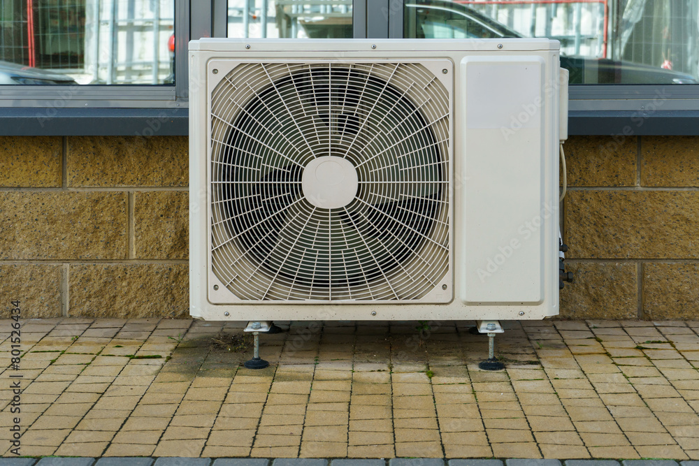 Outdoor air conditioning unit. A large modern air conditioner on the wall of an apartment building. Repair and maintenance of the air conditioning system Outdoor air conditioning unit. A large modern air conditioner on the wall of an apartment building. Repair and maintenance of the air conditioning system
