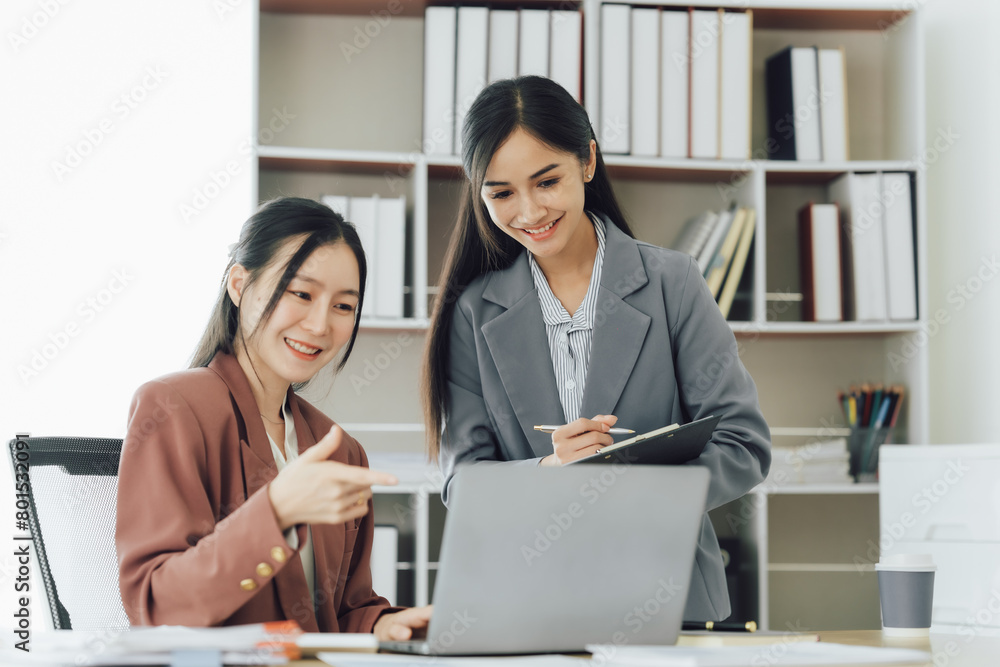 Two young Asian business woman talk, consult, discuss working with new startup project idea presentation analyze plan marketing and investment in the office. Two young Asian business woman talk, consult, discuss working with new startup project idea presentation analyze plan marketing and investment in the office.