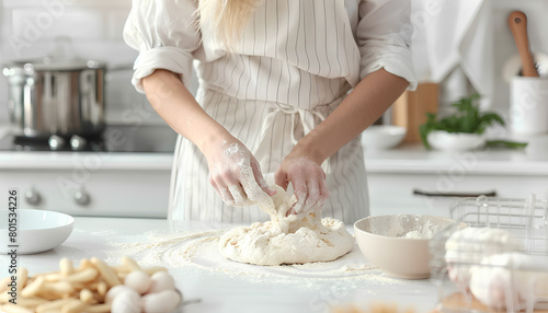 Woman kneading dough for Italian Grissini at white table in kitchen