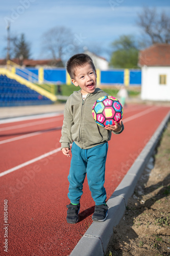 Toddler holding colorful soccer ball
