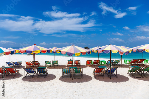 Beach chairs and umbrella on the white sand beach with cloudy blue sky  background
