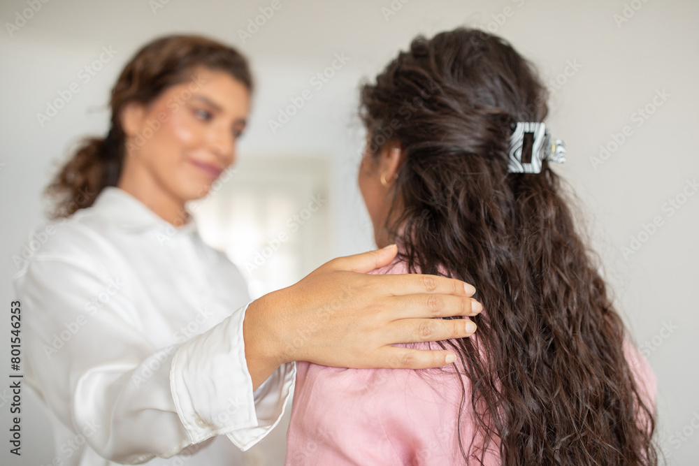 A woman in white offers comfort with a touch on another's lady shoulder in a serene setting, therapy session, mental health concept A woman in white offers comfort with a touch on another's lady shoulder in a serene setting, therapy session, mental health concept