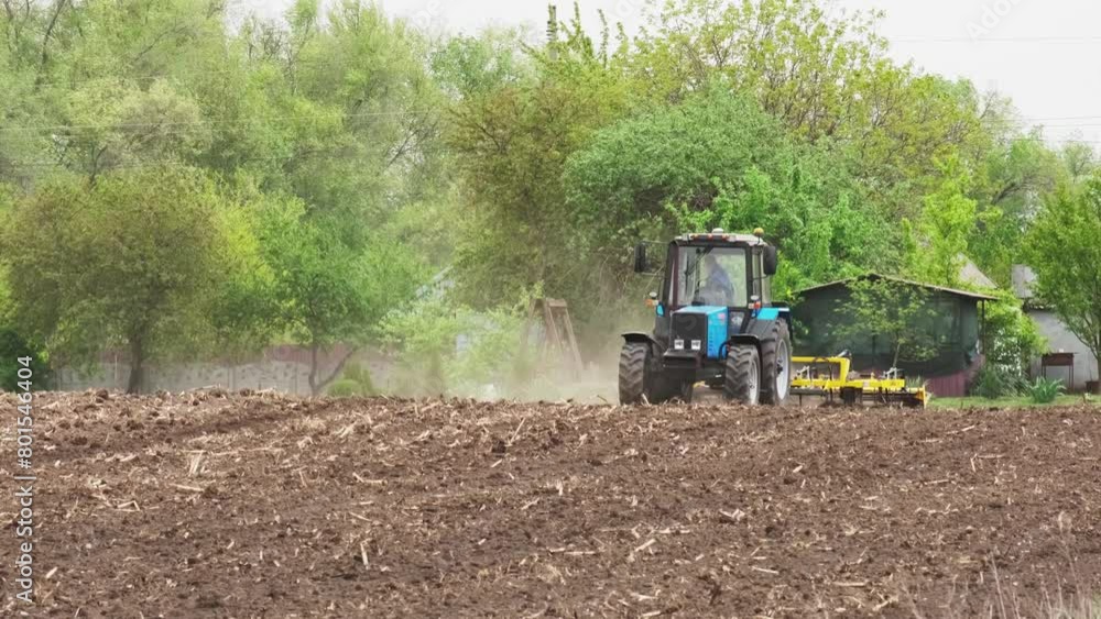 A tractor plows a field in the spring. Agricultural machinery prepares the land for planting, agricultural natural seasonal spring work. A tractor plows a field in the spring. Agricultural machinery prepares the land for planting, agricultural natural seasonal spring work.