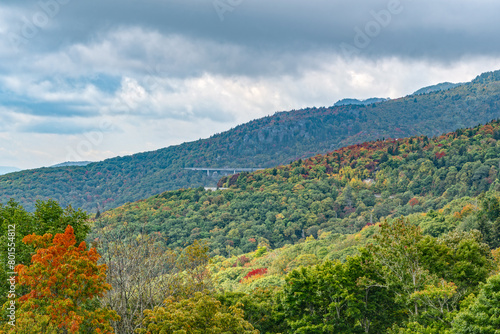 Grandfather Mountain new view Photo is from overlook on blue ridge parkway U can see Linville viaduct on the side going around a bolder field. At the top, the Mile High swinging bridge. Fall colors. 