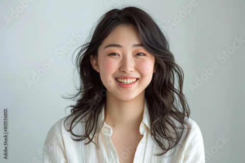 Radiant Asian Woman Poses in Bright Studio for Promotional Brand, Exuding Confidence and Energy